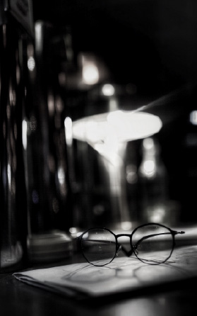 Gafas reposando sobre documentos legales en un escritorio con iluminación cálida, simbolizando reflexión y análisis