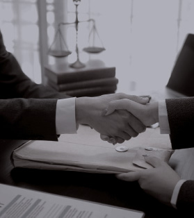 Acuerdo legal entre abogados sellado con un apretón de manos, con documentos y balanza de justicia en el fondo
